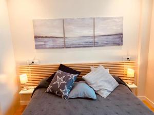 a bedroom with a bed with three paintings on the wall at El Solarón in Gijón +13 photos