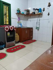a kitchen with rugs on the floor and a stove at Casa da Zélia Hospedagem in Barreirinhas