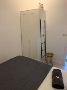 a bedroom with a bed and a ladder and a cabinet at De Nollen in Egmond aan den Hoef