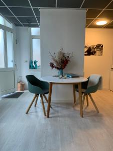 een tafel met twee stoelen en een vaas met bloemen erop bij De Nollen in Egmond aan den Hoef