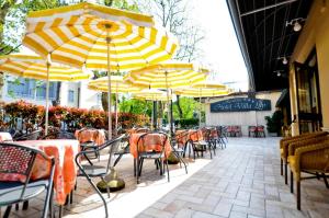 a group of tables and chairs with yellow umbrellas at Hotel Residence Villa Lily in Cesenatico