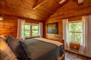 a bedroom with a bed in a log cabin at The Hive at Blue Spruce Lodge White Mnts View in Brownfield