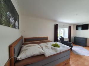 ein Schlafzimmer mit einem großen Bett und einem Stuhl in der Unterkunft Landhaus Oberlausitz in Malschwitz