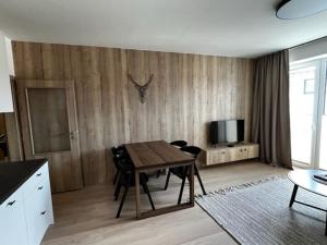 uma sala de estar com uma mesa e uma televisão em KLINOVEC APARTMENTS LUXURY em Loucná pod Klínovcem