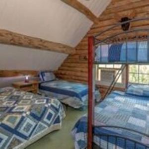 Big Sky Mountain Estate في Brownfield: غرفة نوم مع ثلاثة أسرة بطابقين في كابينة