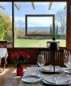 uma sala de jantar com uma mesa e uma grande janela em Tenuta Bussete Country Hotel em Viterbo