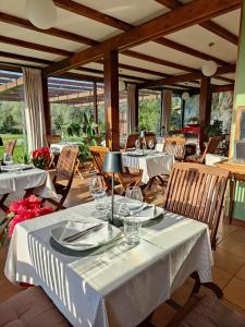 uma sala de jantar com mesas e cadeiras brancas em Tenuta Bussete Country Hotel em Viterbo