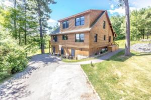 a log home in the woods with a driveway at The Hive Trailside At Pleasant Mnt Ski Area in Bridgton
