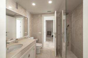 a bathroom with a sink and a toilet and a shower at Houmi Sotogrande in Sotogrande