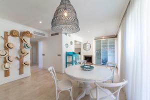 a dining room with a white table and chairs at Houmi Sotogrande in Sotogrande