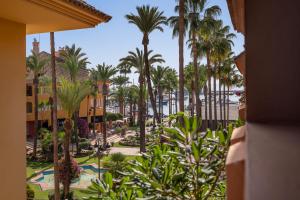 een uitzicht op een resort met palmbomen en een strand bij Houmi Sotogrande in Sotogrande
