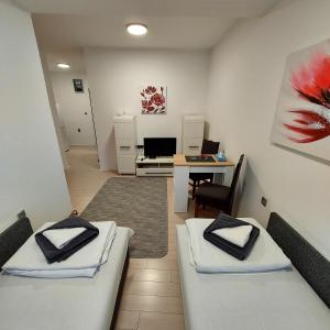 a room with two beds and a desk with a computer at Smestaj Bane in Novi Sad