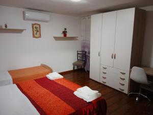 a bedroom with a bed and a cabinet and a desk at Le camille ristorante pizzeria & locanda in Adria