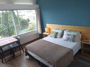 1 dormitorio con cama y ventana grande en Nothofagus Apartments en San Carlos de Bariloche