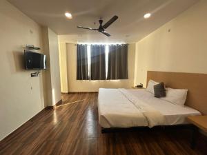 a bedroom with a bed and a ceiling fan at The Chaitanya United Stay in New Delhi