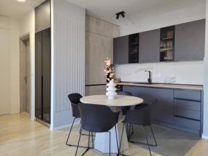 a kitchen with a table and chairs and a sink at BS Apartment in Skopje