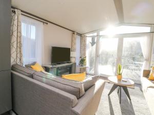 a living room with a couch and a television at Hollybirch in Crieff