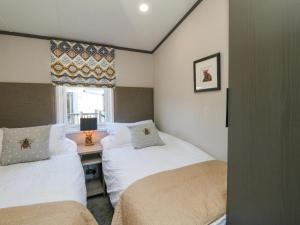 a bedroom with two beds and a desk with a window at Hollybirch in Crieff