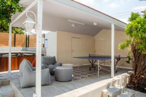 a patio with a ping pong table and chairs at הבית ברחוב הרמבם in Qiryat Shemona