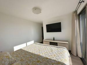 a bedroom with a bed and a flat screen tv at Modern 3 Bedroom Rental Unit With Free Parking in Guatemala