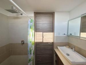 uma casa de banho com uma cortina de chuveiro e um lavatório em Modern 3 Bedroom Rental Unit With Free Parking em Guatemala