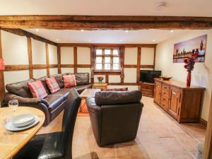 ein Wohnzimmer mit einem Sofa und einem Tisch in der Unterkunft Keepers Cottage in Ludlow
