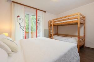 ein weißes Schlafzimmer mit 2 Etagenbetten und einem Fenster in der Unterkunft Kurcamping Erlengrund in Bad Gastein