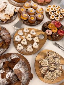 a table full of different types of pastries on plates at Bes Hotel Bergamo Ovest in Mozzo