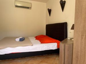 Schlafzimmer mit einem Bett mit roter Bettwäsche und einem schwarzen Kopfteil in der Unterkunft Villa Lavezzi in Bonifacio