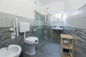 een badkamer met een toilet, een wastafel en een spiegel bij B&B Il Sogno di Mario in Carbonia