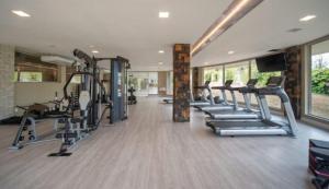 a gym with several treadmills and machines in it at Quarto familia Golden Gramado Resort Laghetto in Gramado