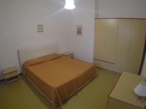 カオルレにあるResidence Adriatico - Agenzia Cocalのベッドルーム1室(ベッド1台、キャビネット、テーブル付)
