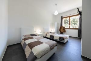 a bedroom with two beds and a window at B&B Il Sogno di Mario in Carbonia