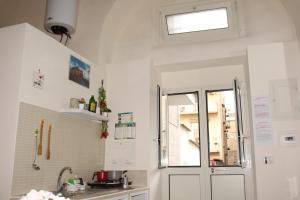 a kitchen with white walls and a window and a sink at Casa Milù Napoli centro in Naples
