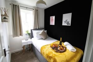 a bedroom with a bed with a bowl of fruit on it at The Cosy House with Free Parking, Garden and Smart TV with Netflix by Yoko Property - Perfect for Contractors, Groups & Relocation in Leamington Spa