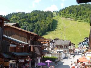 una ciudad con edificios y una colina con un campo verde en Appartement Morzine, 3 pièces, 8 personnes - FR-1-524-2, en Morzine