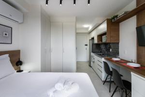 um quarto branco com uma cama branca e uma cozinha em Studio com lazer e varanda no Alto da Boa Vista em São Paulo