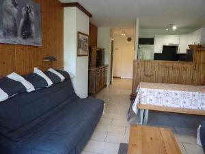 - un salon avec un canapé bleu et une table dans l'établissement Appartement Morzine, 2 pièces, 6 personnes - FR-1-524-20, à Morzine