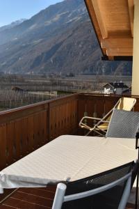 a table and chairs on a balcony with a view at Ferienwohnung Eule in Parcines