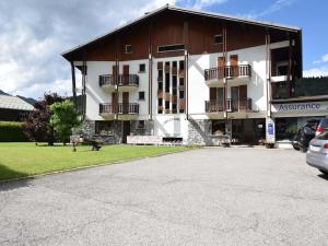 a large white and brown building with a parking lot at Appartement Morzine, 2 pièces, 5 personnes - FR-1-524-37 in Morzine