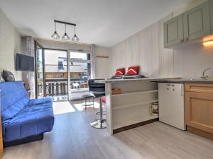eine Küche und ein Wohnzimmer mit einem blauen Sofa in der Unterkunft Studio Morzine, 1 pièce, 6 personnes - FR-1-524-104 in Morzine