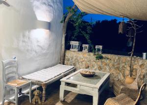 einen Tisch und eine Bank sowie einen Tisch und Stühle in der Unterkunft Casa Mariposa in Es Pujols