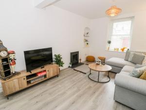 a living room with a flat screen tv and a couch at Cartref Clyd 55 in Porthmadog