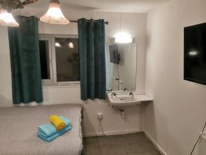 La salle de bains est pourvue d'un lit, d'un lavabo et d'un miroir. dans l'établissement 116 Maison Dieu Road Room D in Dover, à Kent