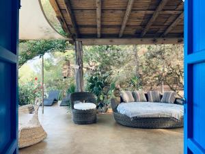 eine Veranda mit einem Sofa und Korbstühlen darauf in der Unterkunft Casa Mariposa in Es Pujols