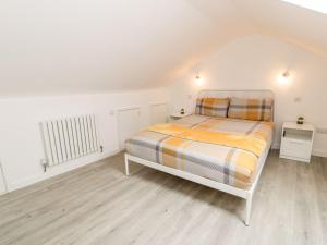 een slaapkamer met een bed in een witte kamer bij Cartref Clyd 55 in Porthmadog