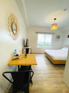 a room with a bed and a table and a desk at Cozy Condo bedroom in Bacolod City in Bacolod