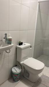 La salle de bains blanche est pourvue de toilettes et d'un lavabo. dans l'établissement Kambô hostel, à São Paulo
