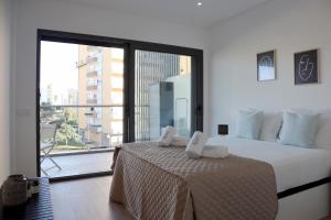 une chambre avec un grand lit avec une grande fenêtre dans l'établissement Monte Residence T1, à Portimão 31 autres photos