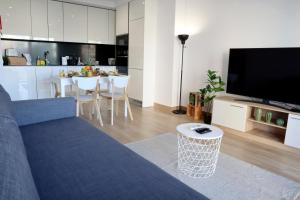 un salon avec un canapé bleu et une cuisine dans l'établissement Monte Residence T1, à Portimão